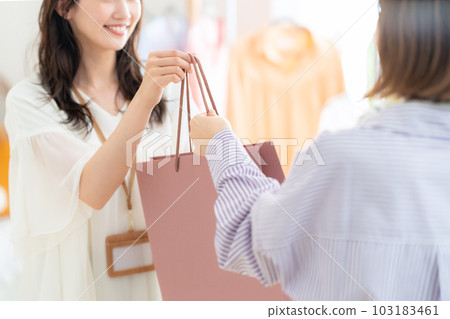 Young female clerk working in an apparel shop Young female clerk working in an apparel shop 103183461