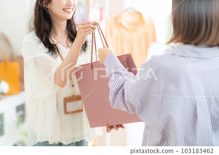 Young female clerk working in an apparel shop 103183462