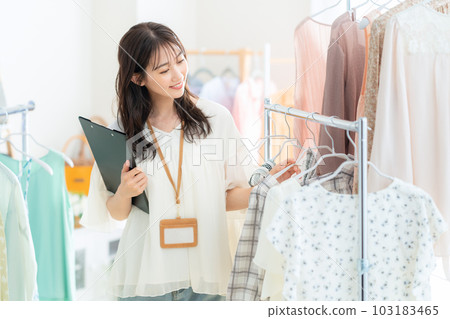 Young female clerk working in an apparel shop Young female clerk working in an apparel shop 103183465