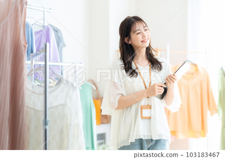 Young female clerk working in an apparel shop 103183467