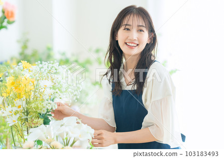 Young female clerk working in a flower shop Young female clerk working in a flower shop 103183493