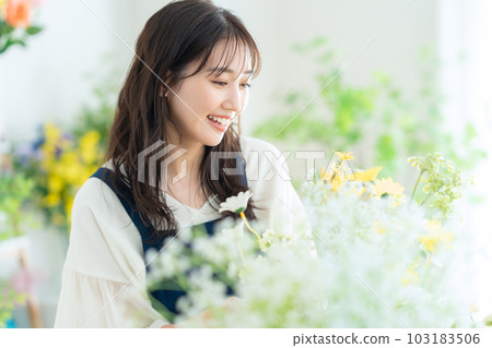 Young female clerk working in a flower shop Young female clerk working in a flower shop 103183506