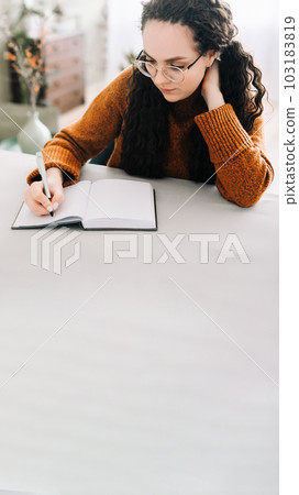 Woman writing in copybook. Business woman or young female student holding pen in hand writing in 103183819