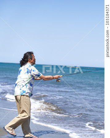 一個男人在陽光明媚的日子在沙灘上釣魚 一個男人在陽光明媚的日子在沙灘上釣魚 103184371