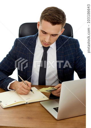 young businessman working on laptop and holding money young businessman working on laptop and holding money 103186643