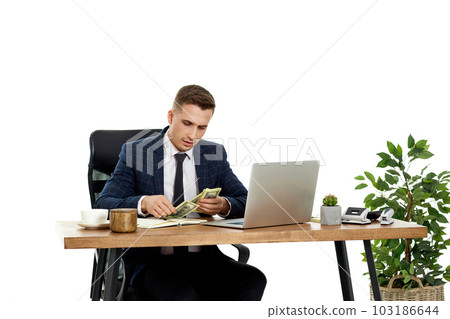 young businessman working on laptop and holding money young businessman working on laptop and holding money 103186644