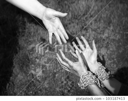 Bound hands reach out to the outstretched hand for help Bound hands reach out to the outstretched hand for help 103187413