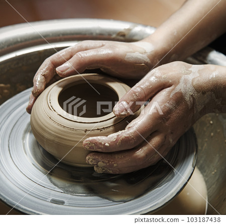 Master's hands mold a jug on a potter's wheel Master's hands mold a jug on a potter's wheel 103187438