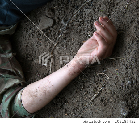 Hand of a wounded soldier on the ground Hand of a wounded soldier on the ground 103187452