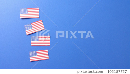 Close up of flags of usa lying on blue background with copy space Close up of flags of usa lying on blue background with copy space 103187757