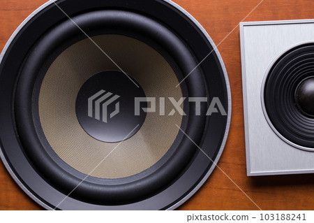 Audio speaker with a wooden brown case on a black background. 103188241