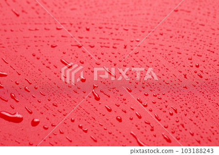 The texture of a water drop on a red background close-up The texture of a water drop on a red background close-up 103188243