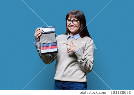 Woman holding samples of fabrics for interior, on blue background Woman holding samples of fabrics for interior, on blue background 103188658