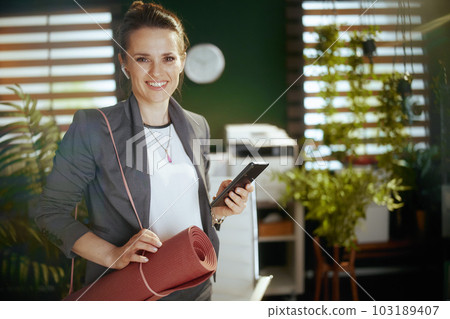 smiling business owner woman in green office 103189407