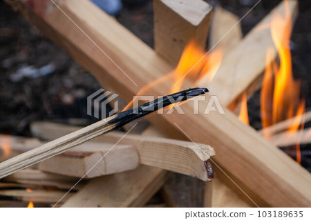 A fire burns in a campfire with a red fire in the background. A fire burns in a campfire with a red fire in the background. 103189635