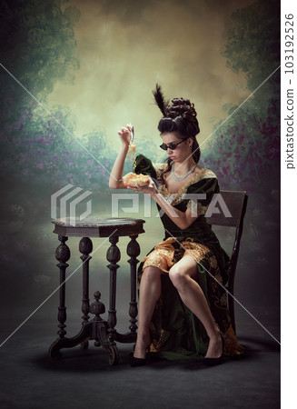Portrait of young beautiful girl , princess in retro dress eating instant noodles. against dark vintage background. Dissatisfaction. Portrait of young beautiful girl , princess in retro dress eating instant noodles. against dark vintage background. Dissatisfaction. 103192526