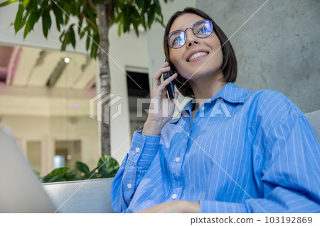 Pleased woman calling on the cellphone indoors Pleased woman calling on the cellphone indoors 103192869