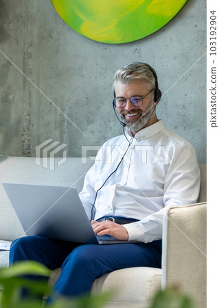 Cheerful businessman working on the laptop in a coworking space 103192904