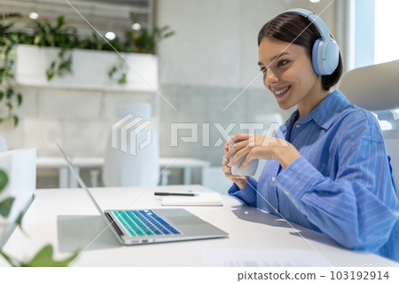 Employee watching something on the laptop screen during the coffee break Employee watching something on the laptop screen during the coffee break 103192914