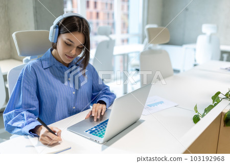 Focused corporate employee writing in her notebook 103192968