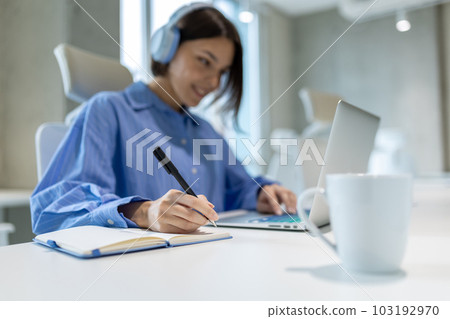 Pleased office worker making notes in her diary Pleased office worker making notes in her diary 103192970