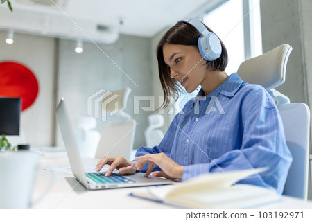 Concentrated corporate worker typing on the portable computer 103192971