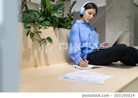 Focused woman making notes in her diary 103193014