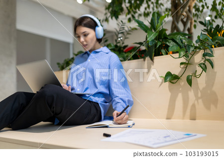 Focused young female watching something on the laptop screen 103193015