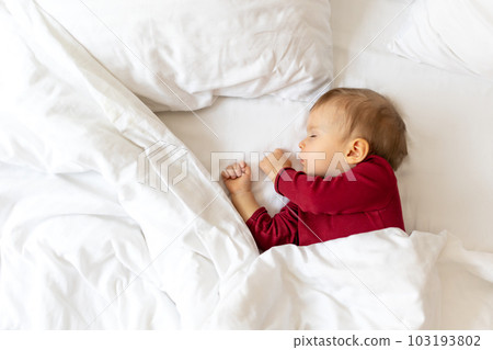 Infant baby sleeping in bed with white linen. 103193802