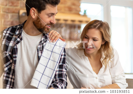 Loving wife and husband preparing dinner, man cooking food communicating with resting woman. Loving wife and husband preparing dinner, man cooking food communicating with resting woman. 103193851