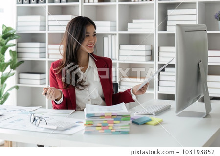Business woman offices working for arranging documents unfinished stack of document papers and using laptop computer. Financial accounting concept Business woman offices working for arranging documents unfinished stack of document papers and using laptop computer. Financial accounting concept 103193852