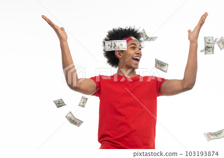 Guy in red tshirt holding money and looking happy 103193874