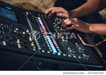 Shot of a multi-track sound mixer for live events with a man's hands on the console pushing fader buttons Shot of a multi-track sound mixer for live events with a man's hands on the console pushing fader buttons 103194150