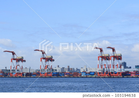 東京港的龍門起重機在貨船上裝卸集裝箱 東京港的龍門起重機在貨船上裝卸集裝箱 103194638