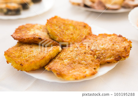 Fried grated potato pancakes with sour cream on white plate 103195288