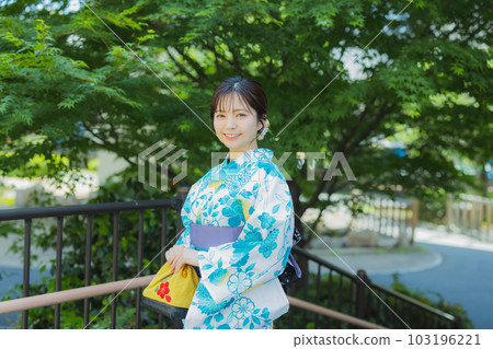 A woman in a yukata walking outdoors 103196221