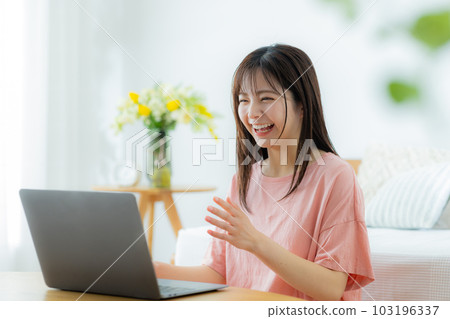 一個女人在客廳裡看電腦 103196337