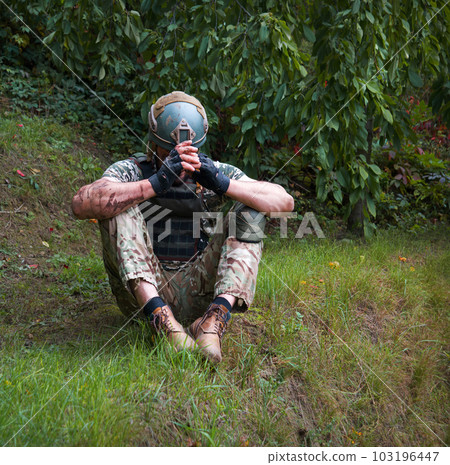 Sad soldier sits on the ground 103196447