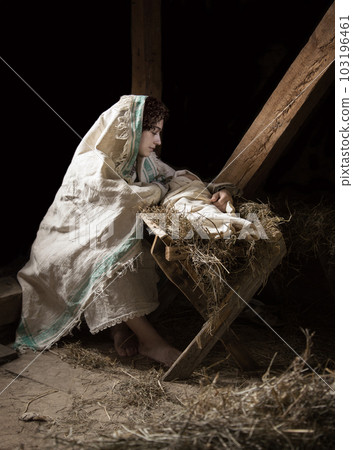 Mary sits in the stable near the manger with the baby Mary sits in the stable near the manger with the baby 103196461