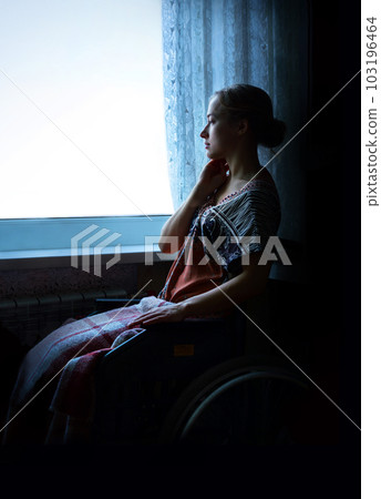 Disabled person in stroller by window Disabled person in stroller by window 103196464