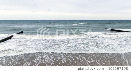 Panoramic beach landscape with shore water and wooden breakwaters 103197198