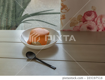 Delicious Homemade Oat Lava Cake with White Sesame in White Ceramic Plate served with Spoon on the White Wooden Table. Delicious Homemade Oat Lava Cake with White Sesame in White Ceramic Plate served with Spoon on the White Wooden Table. 103197518
