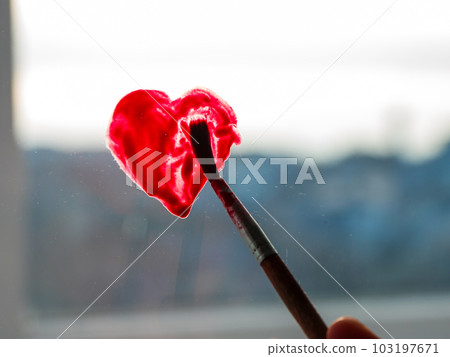 Little girl holds paintbrush in hand drawing red heart on window glass. Valentine's day love, dating, quarantine leisure Little girl holds paintbrush in hand drawing red heart on window glass. Valentine's day love, dating, quarantine leisure 103197671
