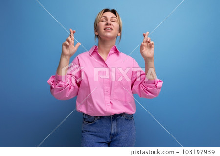young active european blond office worker woman dressed in a pink shirt and jeans shows with her 103197939
