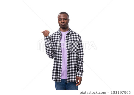 stylish young american guy with short haircut dressed casually pointing with his hand on a white 103197965
