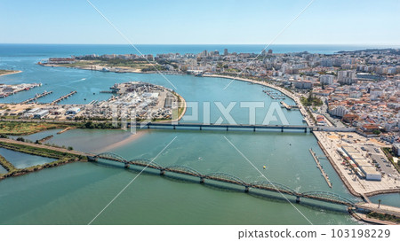 Portuguese bridges over the river Arade overlooking the city of Portimao. Ponte Velha old bridge. view of the marina and the bay. Portuguese bridges over the river Arade overlooking the city of Portimao. Ponte Velha old bridge. view of the marina and the bay. 103198229