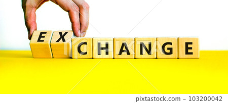Change or exchange symbol. Businessman turns wooden cubes and changes the word change to exchange. Beautiful yellow table, white background, copy space. Business and change or exchange concept. Change or exchange symbol. Businessman turns wooden cubes and changes the word change to exchange. Beautiful yellow table, white background, copy space. Business and change or exchange concept. 103200042