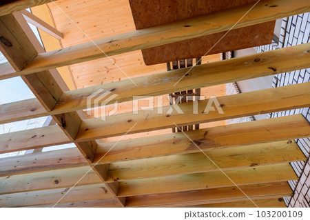 In new custom home deck patio floor joists are being laid out in new manner for wooden deck In new custom home deck patio floor joists are being laid out in new manner for wooden deck 103200109