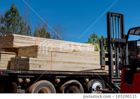 An unloading of wooden building materials on construction site is performed by lift manipulator 103200115
