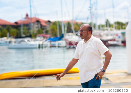 Young man walking in yacht club resort. Young man walking in yacht club resort. 103200320